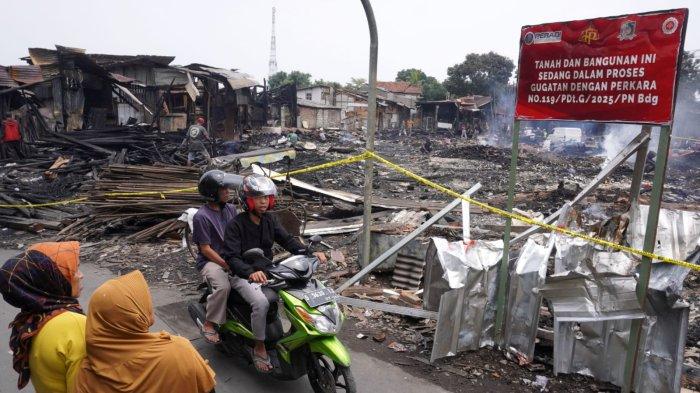 Warga melintasi papan bertuliskan 