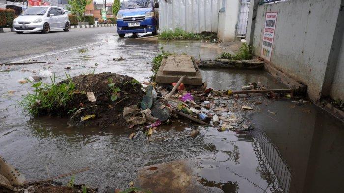 Kendaraan bermotor melintas di samping genangan air di bahu jalan yang meluap dari drainase atau selokan di Jalan Raya Gading Tutuka, Desa Cincin, Kecamatan Soreang, Kabupaten Bandung, Jawa Barat, Jumat (11/4/2025).