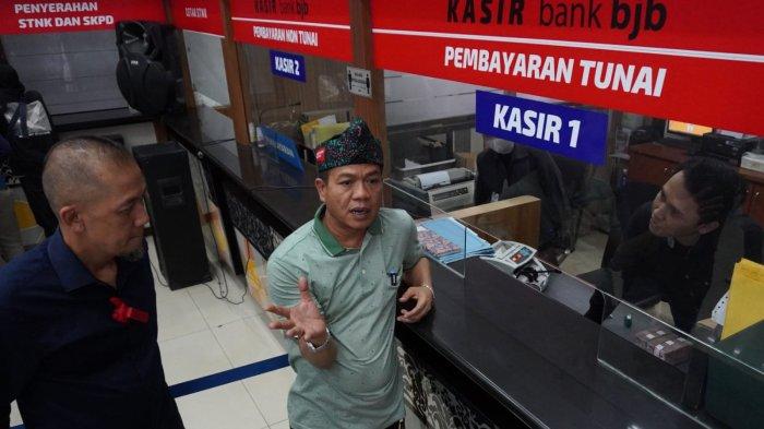 Bupati Bandung, Dadang Supriatna (tengah) didampingi Kepala PPPD Wilayah Kabupaten Bandung II Soreang, Doni Firyanto (kiri) berbincang dengan petugas kasir saat melakukan inspeksi mendadak (sidak) di Kantor Samsat Soreang, Jalan Raya Gading Tutuka, Kabupaten Bandung, Jawa Barat, Jumat (11/4/2025).