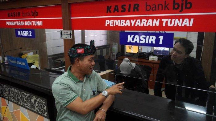 Bupati Bandung, Dadang Supriatna (kiri) berbincang dengan petugas kasir saat melakukan inspeksi mendadak (sidak) di Kantor Samsat Soreang, Jalan Raya Gading Tutuka, Kabupaten Bandung, Jawa Barat, Jumat (11/4/2025).