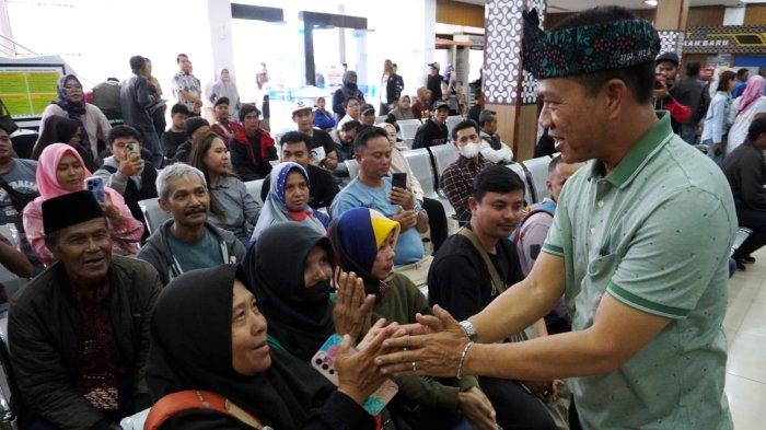 Bupati Bandung, Dadang Supriatna menyapa warga yang akan membayar pajak kendaraan bermotor saat melakukan inspeksi mendadak (sidak) di Kantor Samsat Soreang, Jalan Raya Gading Tutuka, Kabupaten Bandung, Jawa Barat, Jumat (11/4/2025).