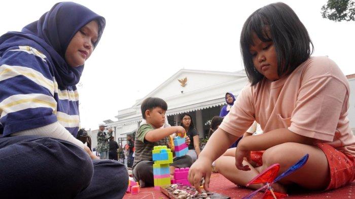 Seorang anak bersama ibunya bermain congklak yang disediakan Mobil Perpustakaan Keliling dalam gelaran Abdi Nagri Nganjang Ka Warga edisi pertama, di halaman Gedung Pakuan, Jalan Otto Iskandardinata, Kota Bandung, Jawa Barat, Sabtu (12/4/2025).