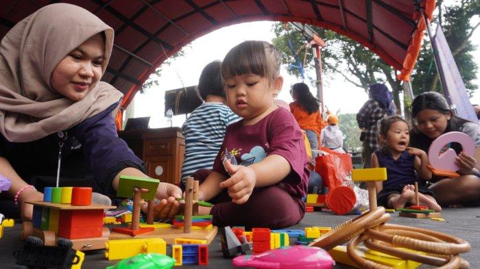 Anak kecil didampingi orang tuanya bermainan mainan di stand Badan Penanggulangan Bencana Daerah (BPBD) Provinsi Jawa Barat dalam gelaran Abdi Nagri Nganjang Ka Warga edisi pertama, di halaman Gedung Pakuan, Jalan Otto Iskandardinata, Kota Bandung, Jawa Barat, Sabtu (12/4/2025).