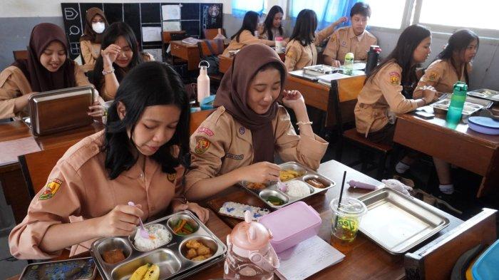 Pelajar menyantap makan bergizi gratis (MBG), di SMAN 20, Jalan Citarum, Kota Bandung, Jawa Barat, Senin (14/4/2025).