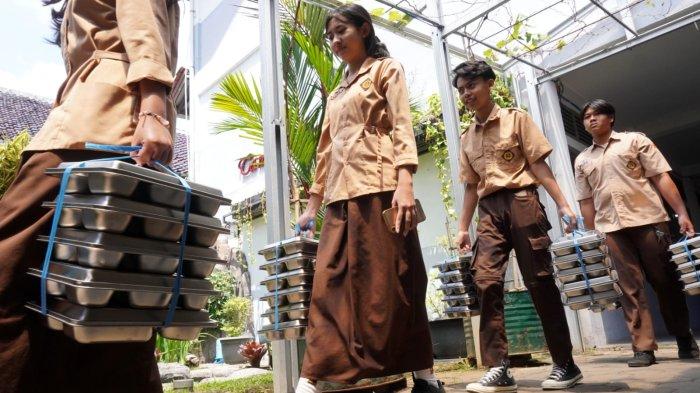 Perwakilan pelajar membawa makan bergizi gratis (MBG) ke kelas masing-masing, di SMAN 20, Jalan Citarum, Kota Bandung, Jawa Barat, Senin (14/4/2025).