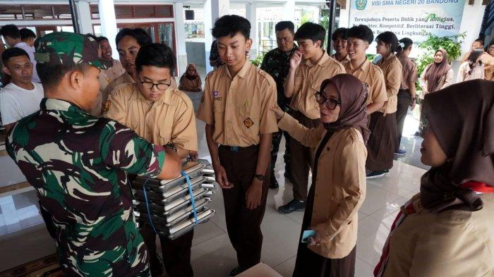 Petugas mendistribusikan makan bergizi gratis (MBG) kepada pelajar, di SMAN 20, Jalan Citarum, Kota Bandung, Jawa Barat, Senin (14/4/2025).