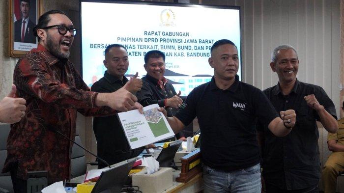 Direktur Eksekutif Walhi Jawa Barat, Wahyudin Iwang menyerahkan draf Potret Kerusakan Lingkungan Hidup di Jawa Barat kepada pimpinan rapat Wakil Ketua DPRD Jabar,Ono Surono, dalam rapat gabungan terkait lingkungan hidup, di Ruang Rapat Badan Musyawarah DPRD Provinsi Jawa Barat, Jalan Diponegoro, Kota Bandung, Selasa (15/4/2025).