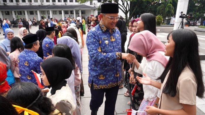 Wali Kota Bandung, Muhammad Farhan dan Wakil Wali Kota Bandung, Erwin menyalami puluhan pelajar putri yang mengenakan kebaya saat memperingati Hari Kartini dalam acara apel pagi, di Plaza Balai Kota Bandung, Jalan Wastukencana, Kota Bandung, Jawa Barat, Senin (21/4/2025).