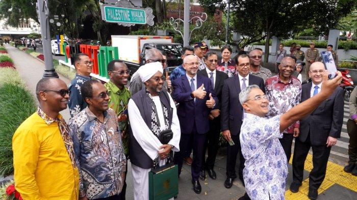Walikota Bandung, Muhammad Farhan berswafoto bersama sejumlah perwakilan dari 17 negara Uni Afrika di area Palestine Walk saat mendampingi para delegasi tersebut melakukan Historical Walk Peringatan 70 Tahun Konferensi Asia Afrika (KAA) di Jalan Asia Afrika, Kota Bandung, Jawa Barat, Rabu (23/4/2025).