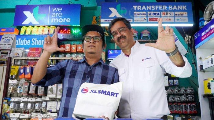 Presiden Direktur & CEO XLSMART, Rajeev Sethi (kanan) berfoto bersama pedagang pulsa saat mengunjungi toko pulsa di kawasan Dago, Kota Bandung, Jawa Barat, Senin (28/4/2025).