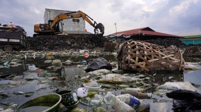 Petugas menggunakan alat berat beko mengumpulkan sampah untuk diangkut dengan truk di Pasar Gedebage, Jalan Soekarno Hatta, Kota Bandung, Jawa Barat, Selasa (29/4/2025).