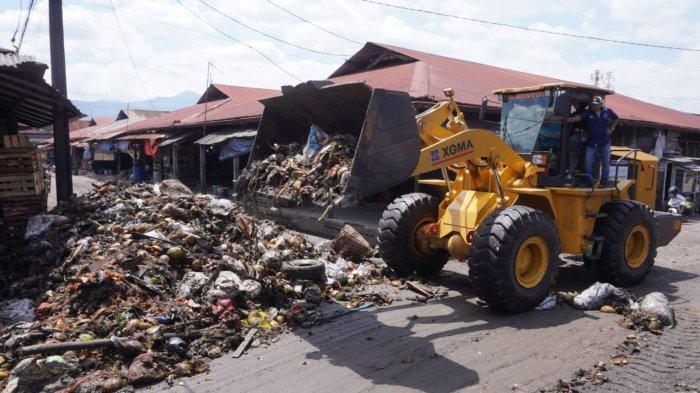 Petugas menggunakan alat berat beko mengumpulkan sampah untuk diangkut dengan truk di Pasar Gedebage, Jalan Soekarno Hatta, Kota Bandung, Jawa Barat, Selasa (29/4/2025).