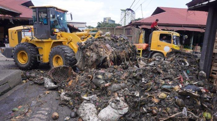 Petugas menggunakan alat berat beko memasukan sampah ke truk di Pasar Gedebage, Jalan Soekarno Hatta, Kota Bandung, Jawa Barat, Selasa (29/4/2025).