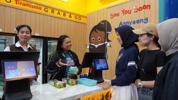 General Manager PT Chocomory Cokelat Persada, Angeline Ariani Setiawati (kedua kiri), melayani para pelanggan setelah melakukan Grand Opening gerai Tiramisusu by Chocomory di Paskal Hyper Square, Kota Bandung, Jawa Barat, Kamis (1/5/2025).