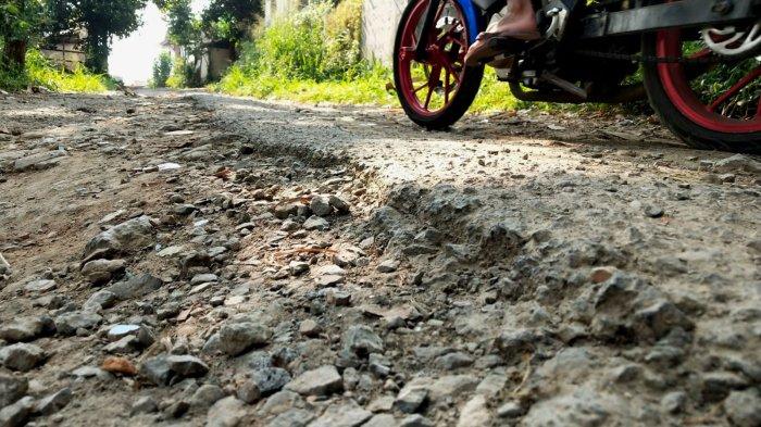 Kendaraan bermotor melintas di Jalan Inspeksi Citarum dengan permukaan rusak, di Desa Mekarrahayu, Kecamatan Margaasih, Kabupaten Bandung, Jawa Barat, Selasa (6/5/2025).