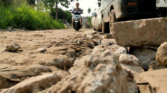 Kendaraan bermotor melintas di Jalan Inspeksi Citarum dengan permukaan rusak, di Desa Mekarrahayu, Kecamatan Margaasih, Kabupaten Bandung, Jawa Barat, Selasa (6/5/2025).