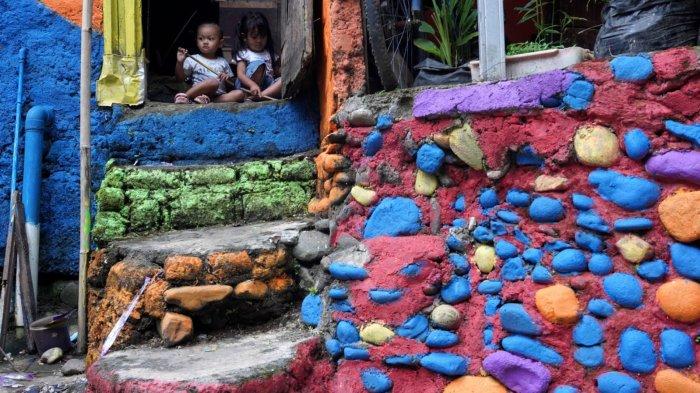 Dua anak kecil bermain di permukiman yang dicat warna warni yang cerah, di Lembur Katumbiri, RW 12, Kelurahan Dago, Kecamatan Coblong, Kota Bandung, Jawa Barat, Selasa (6/5/2025).