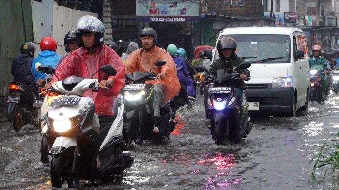 Kendaraan bermotor berjalan pelan saat melintasi genangan banjir cileuncang di Jalan Sayuran, Desa Cangkuang Kulon, Kecamatan Dayeuhkolot, Kabupaten Bandung, Jawa Barat, Rabu (7/5/2025).