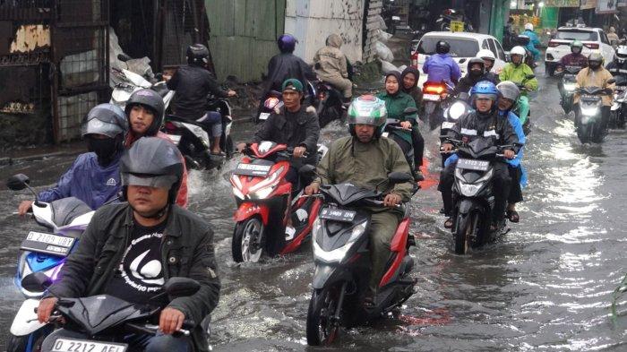 Kendaraan bermotor berjalan pelan saat melintasi genangan banjir cileuncang di Jalan Sayuran, Desa Cangkuang Kulon, Kecamatan Dayeuhkolot, Kabupaten Bandung, Jawa Barat, Rabu (7/5/2025).
