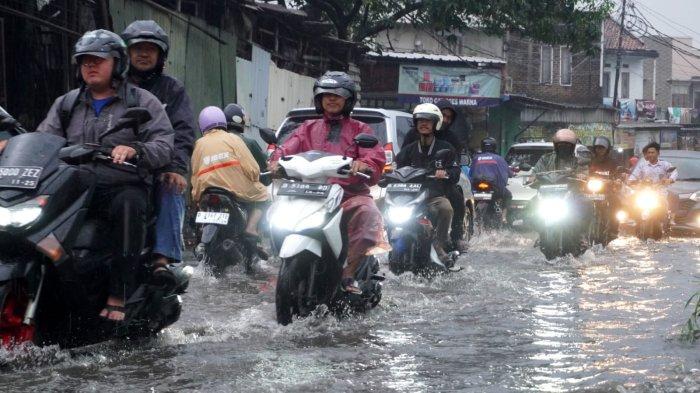 Kendaraan bermotor berjalan pelan saat melintasi genangan banjir cileuncang di Jalan Sayuran, Desa Cangkuang Kulon, Kecamatan Dayeuhkolot, Kabupaten Bandung, Jawa Barat, Rabu (7/5/2025).