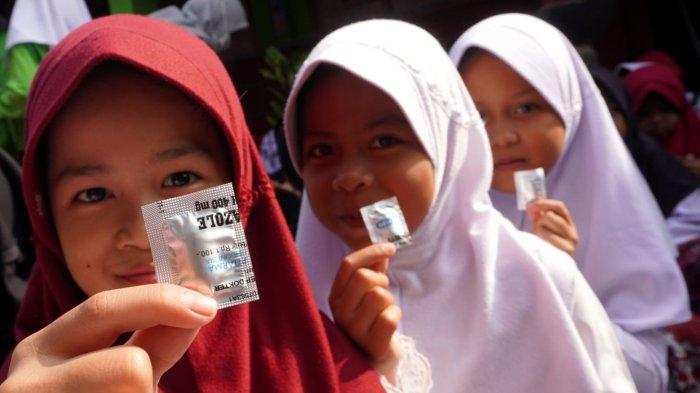 Sejumlah pelajar memperlihatkan obat cacing yang dibagikan secara gratis oleh petugas dari Puskesmas Rancamalaka Endah, di SDN Rancamanyar 3, Jalan Cilebak, Desa Rancamanyar, Kecamatan Baleendah, Kabupaten Bandung, Jawa Barat, Kamis (8/5/2025).