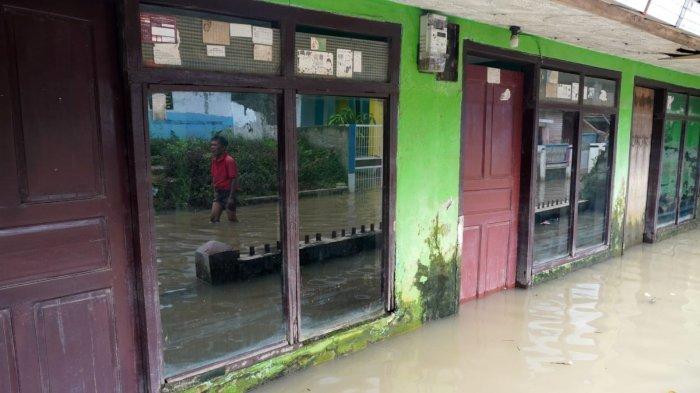 Warga melintasi banjir yang merendam jalan di Kampung Bojongasih, Desa/Kecamatan Dayeuhkolot, Kabupaten Bandung, Jawa Barat, Kamis (15/5/2025).