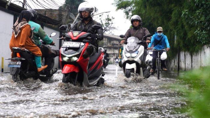 Kendaraan bermotor melintasi banjir cileuncang yang menggenangi Jalan Cisirung, Dayeuhkolot, Kabupaten Bandung, Jawa Barat, Jumat (16/5/2025).