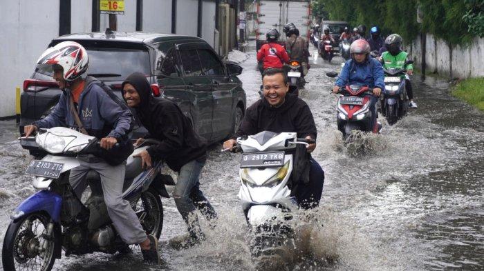 Kendaraan bermotor melintasi banjir cileuncang yang menggenangi Jalan Cisirung, Dayeuhkolot, Kabupaten Bandung, Jawa Barat, Jumat (16/5/2025).