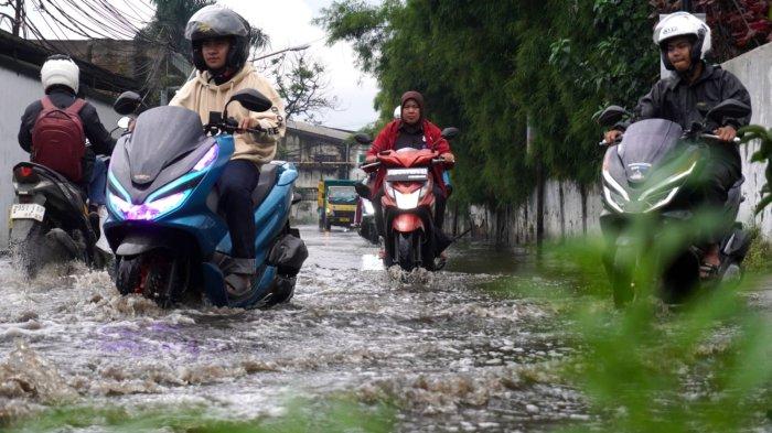 Kendaraan bermotor melintasi banjir cileuncang yang menggenangi Jalan Cisirung, Dayeuhkolot, Kabupaten Bandung, Jawa Barat, Jumat (16/5/2025).