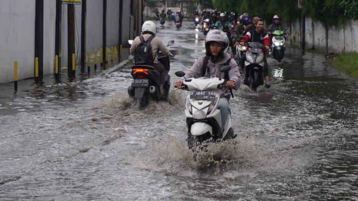 Kendaraan bermotor melintasi banjir cileuncang yang menggenangi Jalan Cisirung, Dayeuhkolot, Kabupaten Bandung, Jawa Barat, Jumat (16/5/2025).