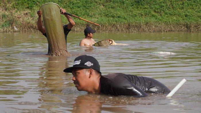 Sejumlah pria berburu cacing sutra di Sungai Citarum, Kabupaten Bandung, Jawa Barat, Senin (19/5/2025).