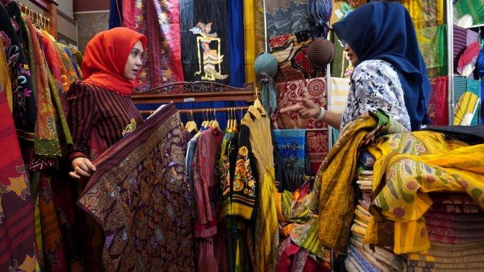 Pengunjung melihat pakaian dari kain tenun di salah satu stan pada gelaran Festival Batik, Bordir, Tenun, dan Kerajinan Nusantara, di Graha Manggala Siliwangi, Jalan Aceh, Kota Bandung, Jawa Barat, Kamis (29/5/2025).