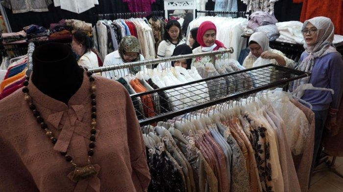 Pengunjung melihat pakaian dari kain tenun dan bordir di salah satu stan pada gelaran Festival Batik, Bordir, Tenun, dan Kerajinan Nusantara, di Graha Manggala Siliwangi, Jalan Aceh, Kota Bandung, Jawa Barat, Kamis (29/5/2025).