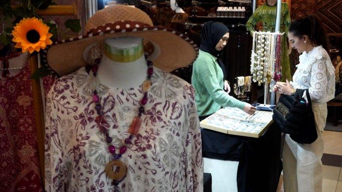 Pengunjung melihat kerajinan tangan berupa asesoris di salah satu stan pada gelaran Festival Batik, Bordir, Tenun, dan Kerajinan Nusantara, di Graha Manggala Siliwangi, Jalan Aceh, Kota Bandung, Jawa Barat, Kamis (29/5/2025).
