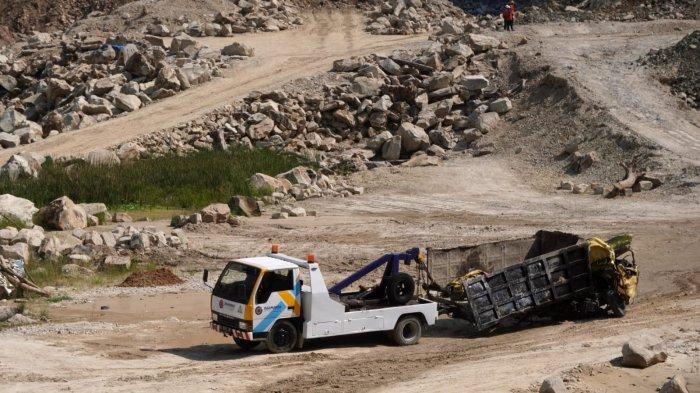 Petugas menggunakan truk derek memindahkan satu unit truk yang hancur tertimbun dari lokasi longsor Tambang Galian C, Gunung Kuda, Desa Cipanas, Kecamatan Dukupuntang, Kabupaten Cirebon, Jawa Barat, Sabtu (31/5/2025).