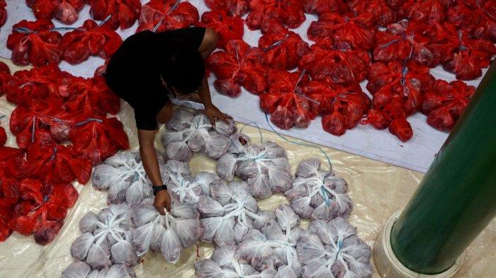 Petugas mengumpulkan daging kurban yang sudah dibungkus untuk segera didistriusikan pada Iduladha 1446 H, di Masjid Lautze 2, Jalan Tamlong, Kota Bandung, Jawa Barat, Jumat (6/6/2025).