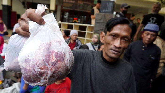 Seorang mustahik yang sebelumnya telah memiliki kupon menerima daging kurban pada Iduladha 1446 H, di area depan Masjid Al-Lathiif, Kota Bandung, Jawa Barat, Sabtu (7/6/2025).