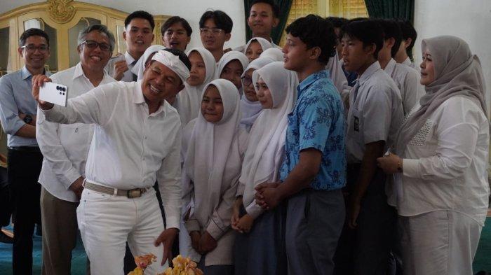Gubernur Jawa Barat, Dedi Mulyadi disaksikan Rektor ITB, Tatacipta Dirgantara (kedua kiri), membuat konten bersama para calon mahasiswa baru ITB angkatan 2025 asal Jawa Barat penerima bantuan, di Bale Sri Baduga, Kabupaten Purwakarta, Jawa Barat, Rabu (18/6/2025).