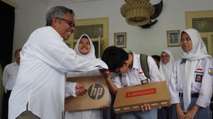 Rektor ITB, Tatacipta Dirgantara (kiri) menyerahkan bantuan laptop kepada para calon mahasiswa baru ITB angkatan 2025 asal Jawa Barat penerima bantuan, di Bale Sri Baduga, Kabupaten Purwakarta, Jawa Barat, Rabu (18/6/2025).