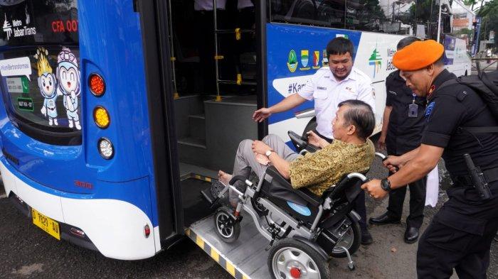 Tamu undangan mengenakan kursi roda turun dari Bus Metro Jabar Trans saat melakukan uji coba penggunaan Kartu Multi Trip (KMT) usai peluncuran Cashless Payment KMT di Bus Metro Jabar Trans, di Jalan Kebon Kawung depan Stasiun Bandung, Kota Bandung, Jawa Barat, Kamis (19/6/2025).