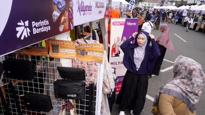 Pengunjung berbincang dengan salah satu pelaku UMKM peserta Bazaar Berdaya Bersama 2025 di Jalan Braga, Kota Bandung, Jawa Barat, Sabtu (21/6/2025).
