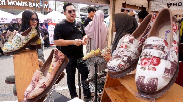 Pengunjung berbincang dengan salah satu pelaku UMKM peserta Bazaar Berdaya Bersama 2025 di Jalan Braga, Kota Bandung, Jawa Barat, Sabtu (21/6/2025).