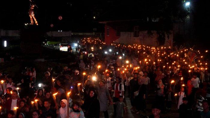 Warga mengikuti pawai obor di Kelurahan Babakan Ciamis, Kecamatan Sumur Bandung, Kota Bandung, Jawa Barat, Kamis (26/6/2025) malam.