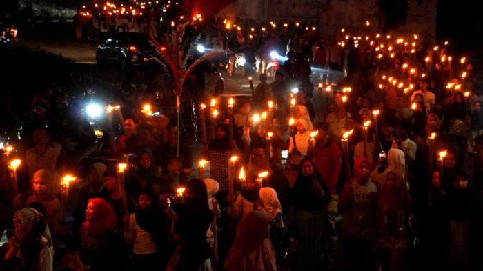 Warga mengikuti pawai obor di Kelurahan Babakan Ciamis, Kecamatan Sumur Bandung, Kota Bandung, Jawa Barat, Kamis (26/6/2025) malam.