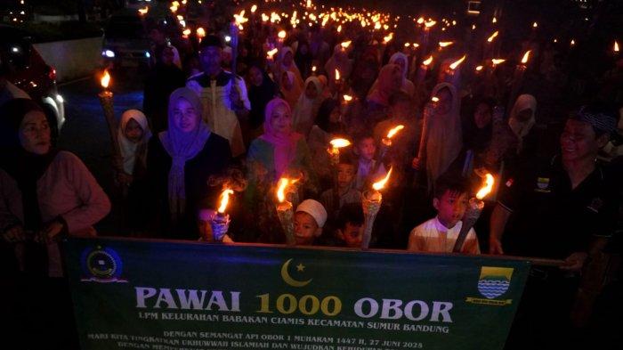 Warga mengikuti pawai obor di Kelurahan Babakan Ciamis, Kecamatan Sumur Bandung, Kota Bandung, Jawa Barat, Kamis (26/6/2025) malam.