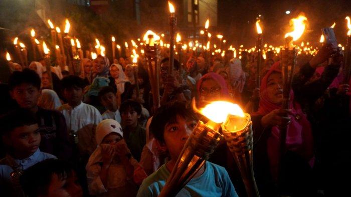 Warga mengikuti pawai obor di Kelurahan Babakan Ciamis, Kecamatan Sumur Bandung, Kota Bandung, Jawa Barat, Kamis (26/6/2025) malam.