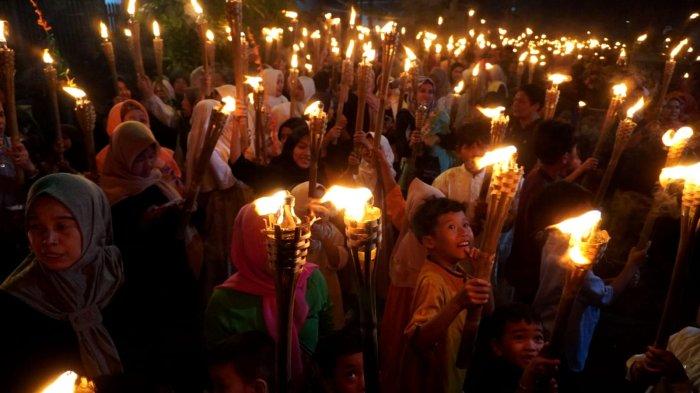 Warga mengikuti pawai obor di Kelurahan Babakan Ciamis, Kecamatan Sumur Bandung, Kota Bandung, Jawa Barat, Kamis (26/6/2025) malam.