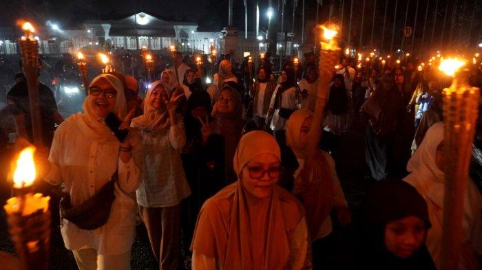Warga mengikuti pawai obor di Kelurahan Babakan Ciamis, Kecamatan Sumur Bandung, Kota Bandung, Jawa Barat, Kamis (26/6/2025) malam.