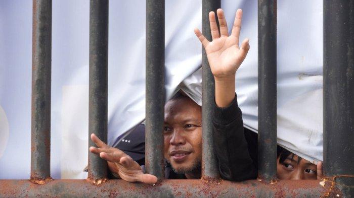 Sejumlah bobotoh dari balik banner penutup lapangan yang robel mengintip latihan perdana Persib Bandung di lapangan pendamping Stadion Gelora Bandung Lautan Api (GBLA), Kota Bandung, Jawa Barat, Senin (30/6/2025) pagi.