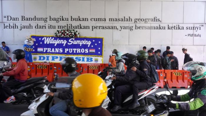 Maskot Si Maung Bandung (Simba) memperkenalkan pemain anyar Persib Bandung, Frans Putros, yang namanya tertera pada karangan bunga bertuliskan Wilujeng Sumping di Persib, di bawah Jembatan Penyeberangan Orang (JPO), Jalan Asia Afrika, Kota Bandung, Jawa Barat, Rabu (16/7/2025).